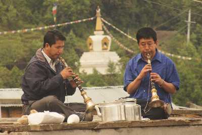 Trumpet blowers announcing a Buddhist temple ceremony in Tarke Gyang, Helambu, Nepal
